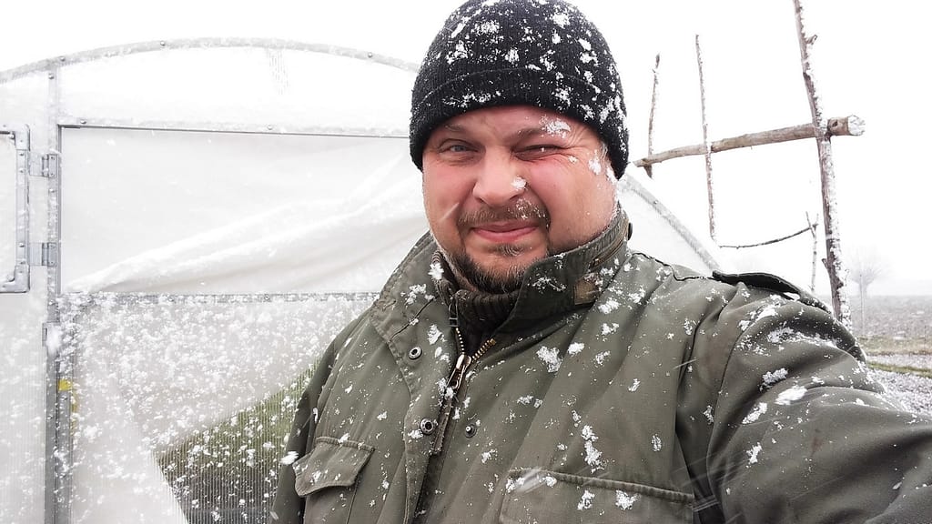 O NAS Adam sprawdza szklarnię zimą podczas opadów śniegu